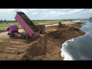 Impressive skill A bulldozer works in tandem with a dump