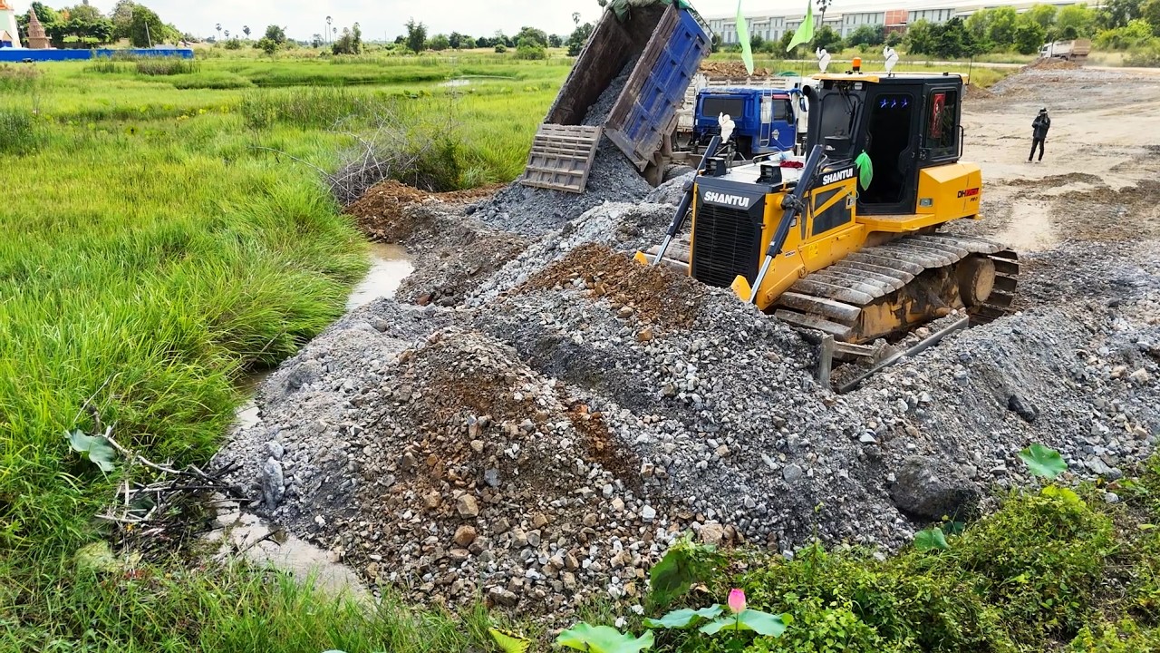 Dump Truck Discharging Crushed Rocks To Fill Wetland Pond