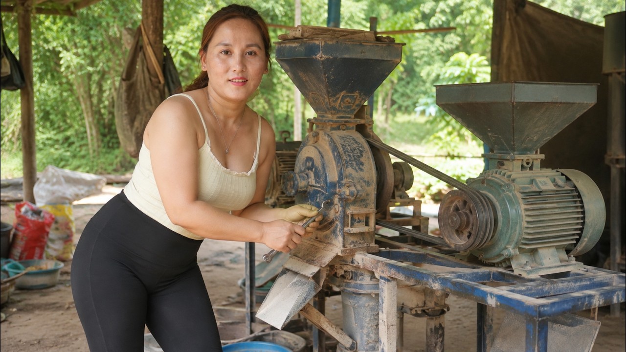 Young woman repairs an old rice milling machine herself