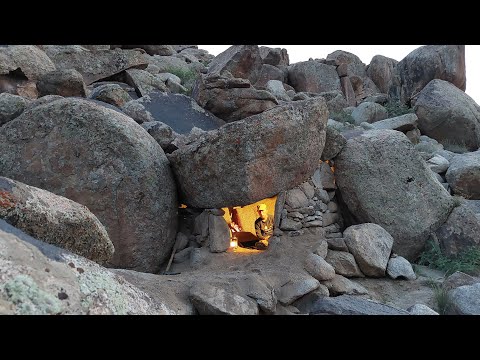 Building a handmade rock shelter in the mountains.