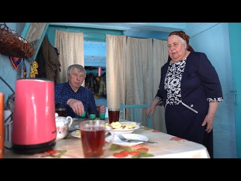Happy elderly couple lives in the taiga forest far from