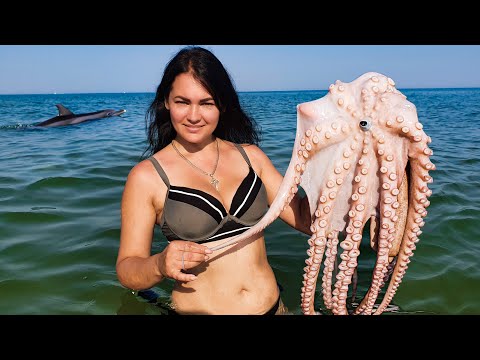 Gentle cooking of an octopus on the shore performed by a