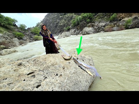 Local woman catches fish in a raging river