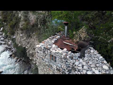 A man is restoring a stone house in the mountains Spends