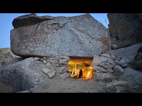 I built a shelter beneath a massive rock to survive the