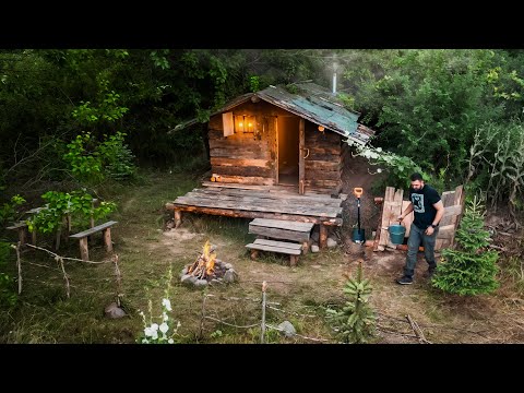 The man built a well near the log cabins in the forest