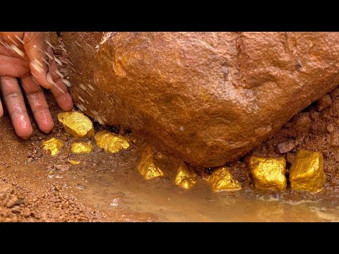 Finding and digging treasure gold under stone at mountain
