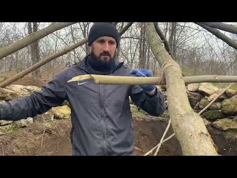 Building of a round bushcraft dugout for survival in the