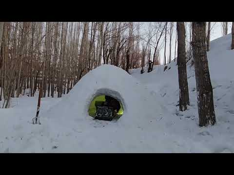 Alone on a snowy mountain peak camping alone in winter with