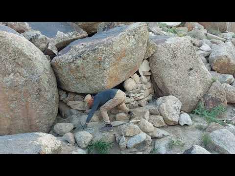 Building a handmade rock shelter in the mountains