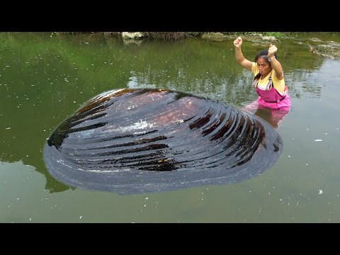 A beautiful woman smashed open a river clam and beautiful