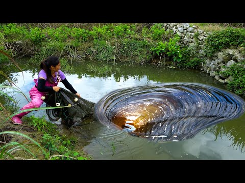 Beautiful woman goes to the ground to catch river clams it