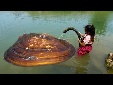 A beautiful woman picked up a big river clam and I m