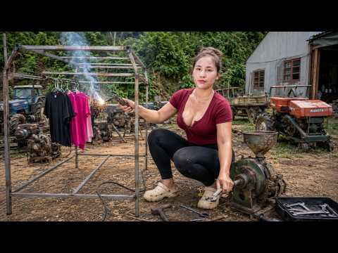 A beautiful country girl repairs a cassava grinder and