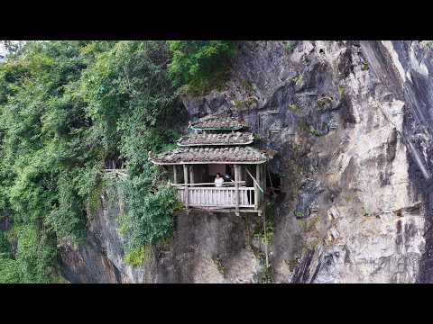 重庆一大山绝壁上竟发现凌空悬挂着一座木房子 底部仅靠着两根木棍支撑 太惊险了 Wooden house hanging