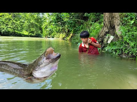 The boy caught a big fish in stream Fishing during flood
