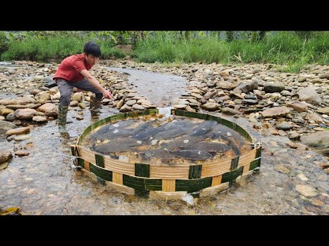 The young man using ancient fishing methods in the stream