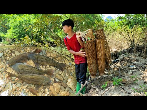 The boy used a bamboo basket to drop into the stream and