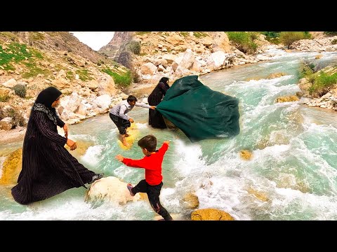 vashing the blankets in the river by village couple