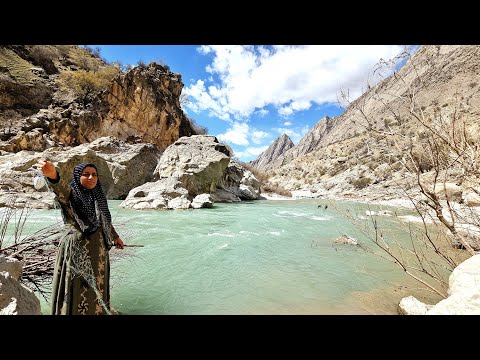 Fishing in the roaring river by a nomadic woman