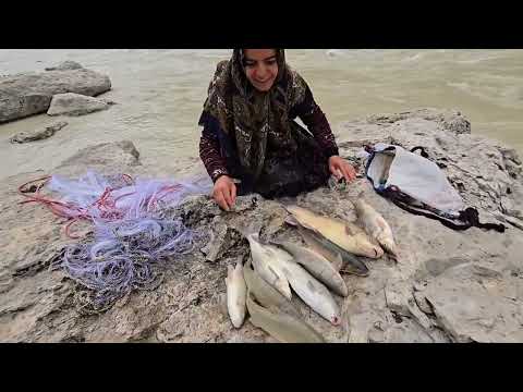 Local woman catches fish in a raging river