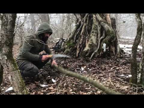 winter bushcraft camping in tree trunk lost in snow forest