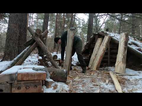 Solo bushcraft in a dugout planks of logs work in the woods